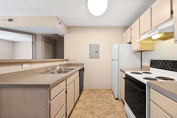 A kitchen with a white refrigerator and black stove top oven.