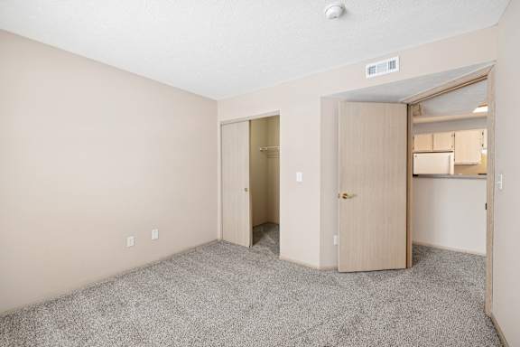 A room with two doors and a carpeted floor.