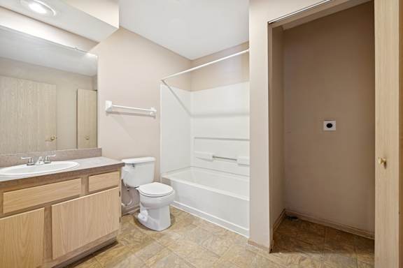 A bathroom with a toilet, sink, and bathtub.
