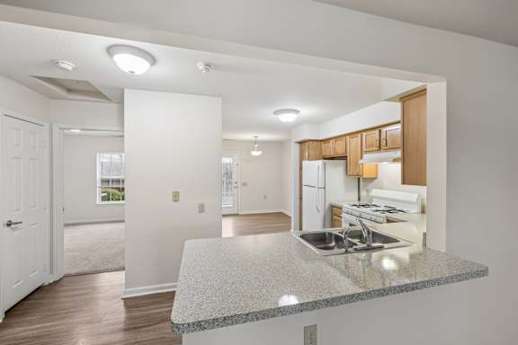 A kitchen with a granite countertop and wooden cabinets.