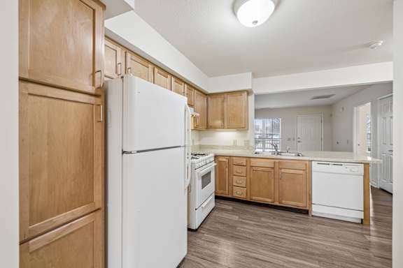 A kitchen with wooden cabinets and a white refrigerator.