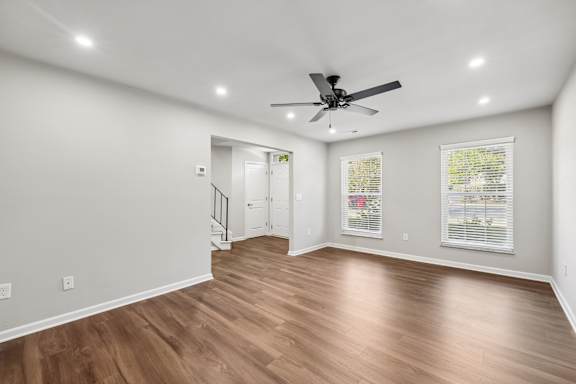 A room with a ceiling fan and wooden flooring.