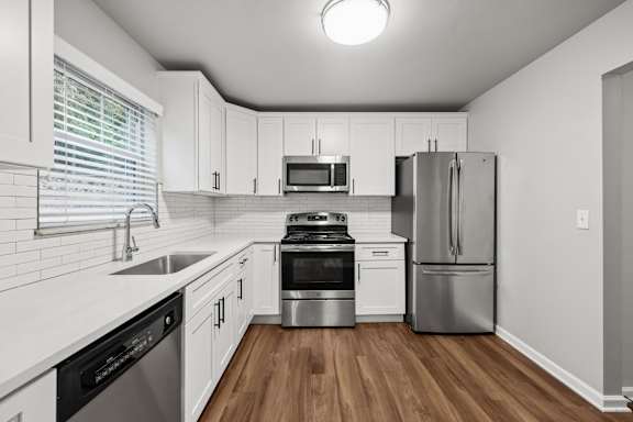 A kitchen with white cabinets and stainless steel appliances.