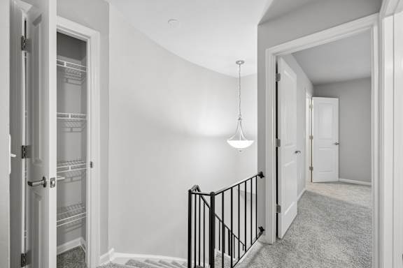 A black and white photo of a hallway with a staircase.