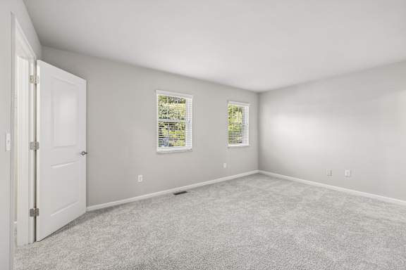 A room with a white door and a window with blinds.
