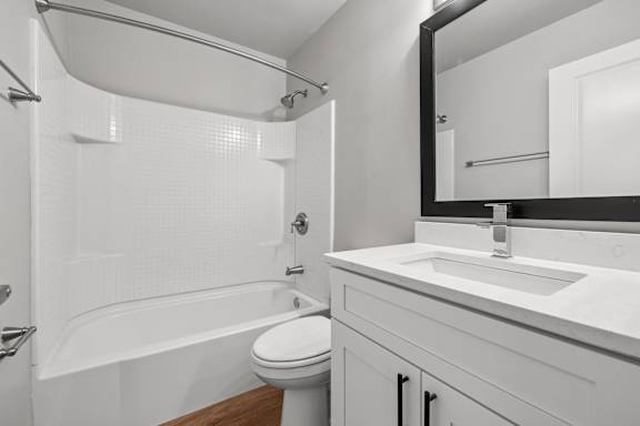 A white bathroom with a toilet, sink, and bathtub.