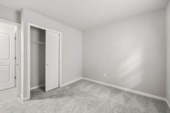 A white door is open in a room with carpeted floor.