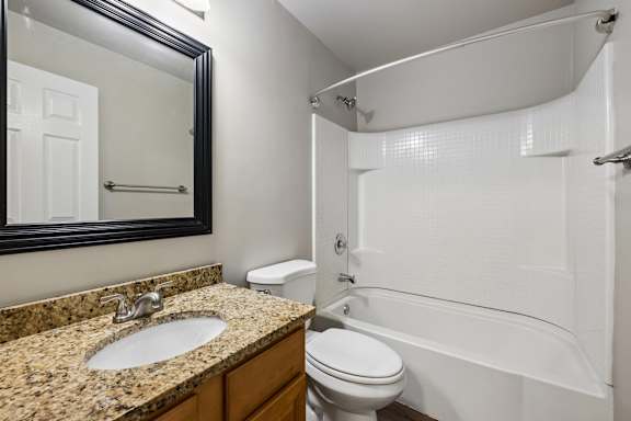 A bathroom with a sink, toilet, and bathtub.