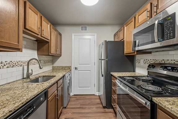 A kitchen with granite countertops and stainless steel appliances.