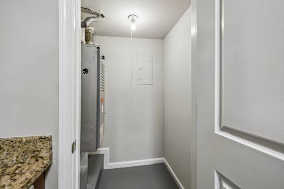 A small, white, metal box is mounted on a wall.