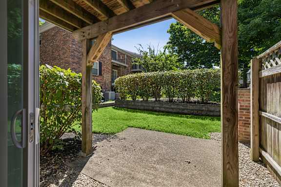 A wooden pergola over a concrete walkway.