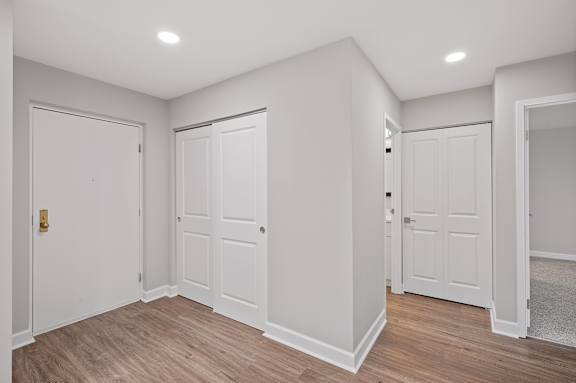 A room with white walls and wooden flooring with three doors. at Indian Creek Apartments*, Cincinnati, OH