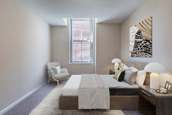 Furnished bedroom with neutral decor and skylight at Renaissance at the Power Building Apartments, Cincinnati, OH