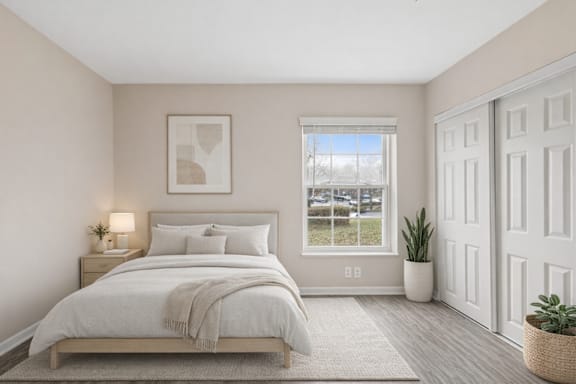 A bedroom with a large bed and a window overlooking a parking lot.