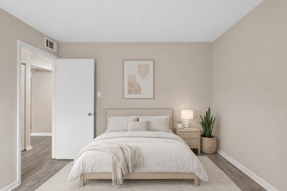 A bedroom with a bed, nightstand, and lamp.