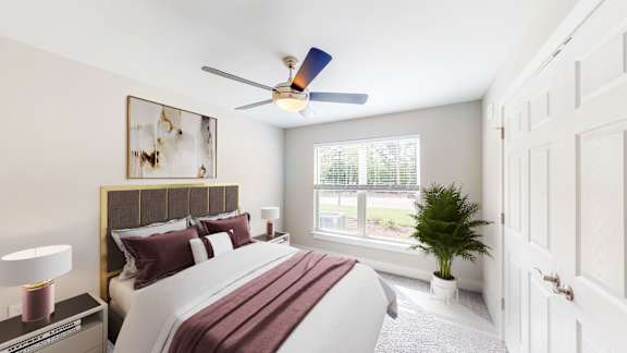 A bedroom with a large bed and a ceiling fan.