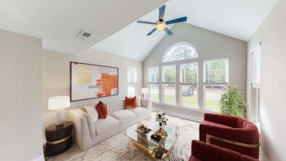 A living room with a red armchair and a painting on the wall.