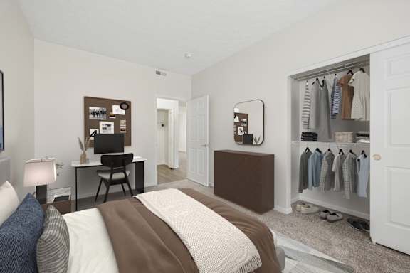 A bedroom with a bed, a desk, a chair, a wardrobe, and a mirror.