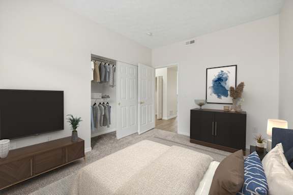 A bedroom with a large bed and a TV on the wall.