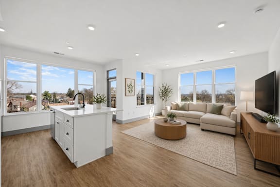 A modern kitchen with a large island and a view of the city.