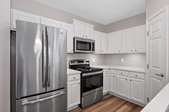 A kitchen with a stainless steel refrigerator, microwave, oven, and cabinets. at Roebling Row, Covington, KY