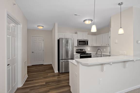 A kitchen with white cabinets and a white island. at Roebling Row, Covington, KY, 41011-1720