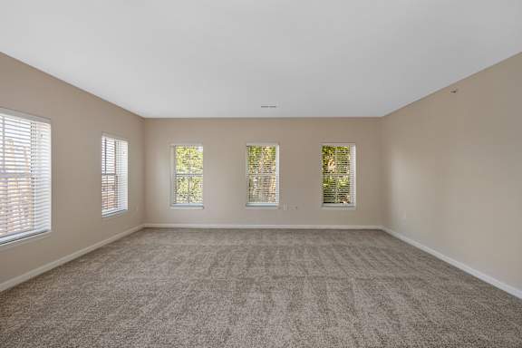 A large empty room with carpeted floor and three windows. at Roebling Row, Kentucky, 41011-1720