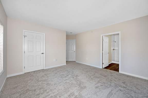 A room with a carpeted floor and two doors. at Roebling Row, Kentucky