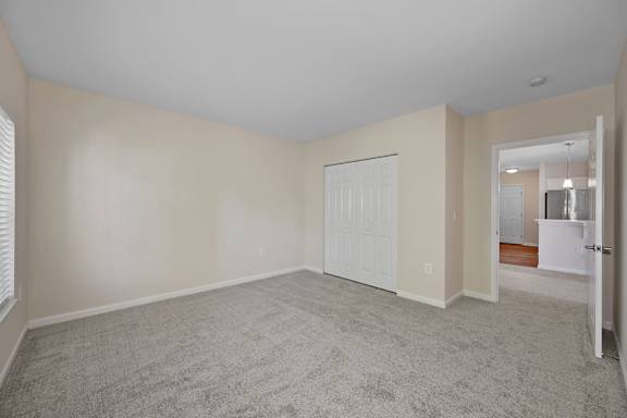 A room with a carpeted floor and a white door. at Roebling Row, Kentucky