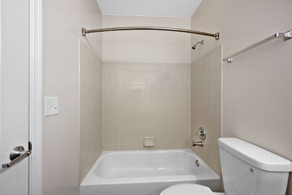 A white bathroom with a tub, toilet and sink. at Roebling Row, Covington, Kentucky