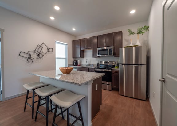 A kitchen with a white countertop and brown cabinets.