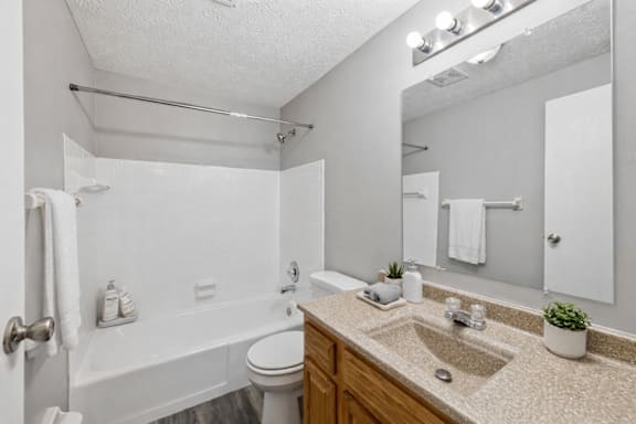 A white bathroom with a toilet, sink, and bathtub.
