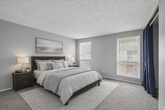 A bedroom with a large bed and a painting on the wall.