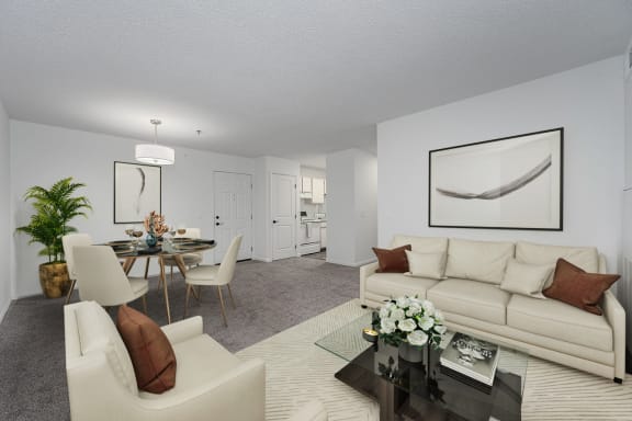 a living room with white furniture and a dining room with a table and chairs