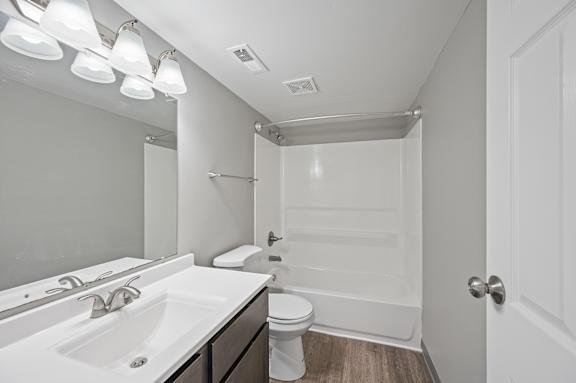 A white bathroom with a toilet, sink, and shower.