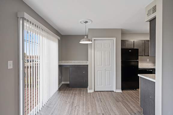 A kitchen with a black fridge and a white door.