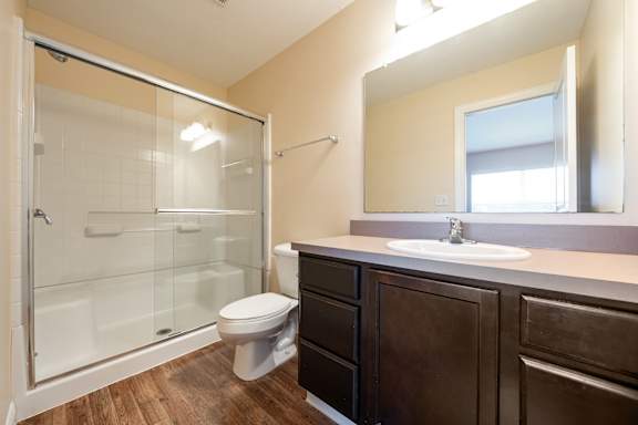 A bathroom with a toilet, sink, and shower.