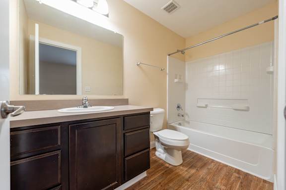 A bathroom with a toilet, sink, and shower.