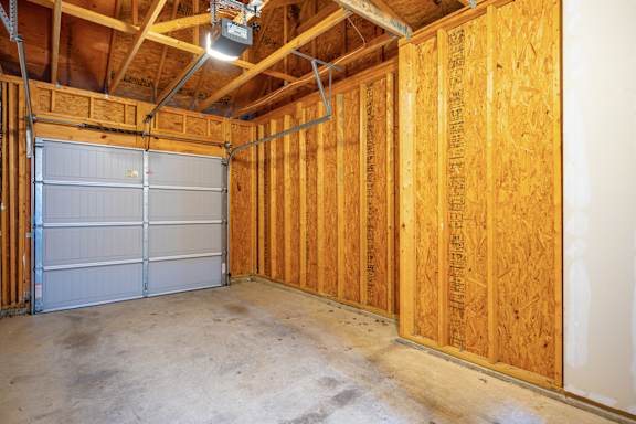 A garage with a white door and wooden walls.