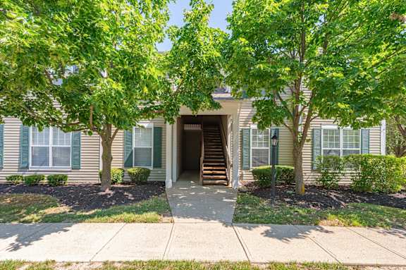 A house with a front yard and a tree.
