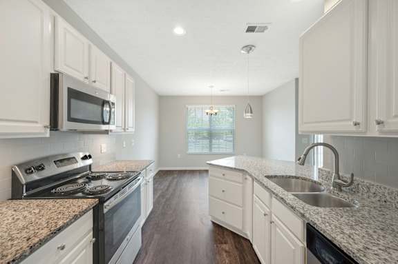 A kitchen with granite countertops and white cabinets.