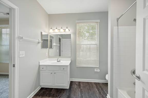 A bathroom with a white sink and a large mirror.