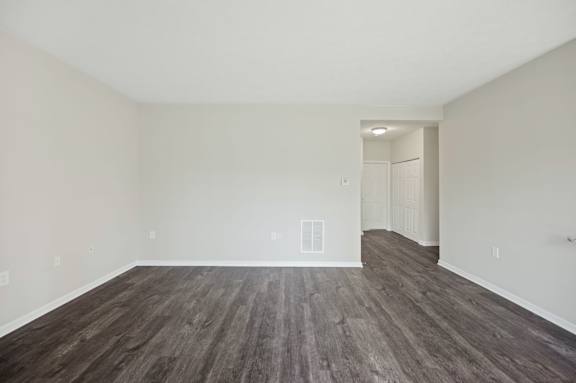 A room with wooden flooring and white walls.