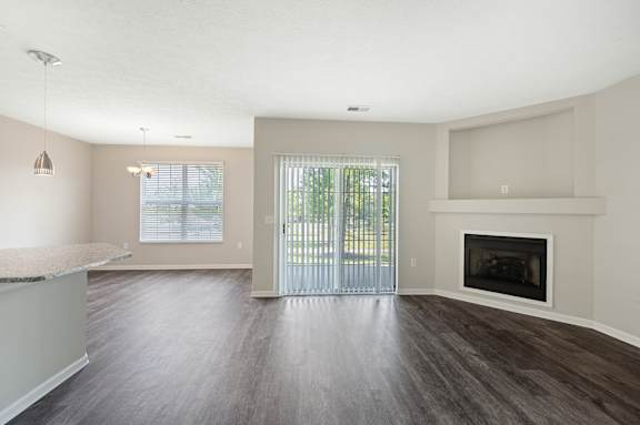 A spacious living room with a fireplace and sliding glass doors.