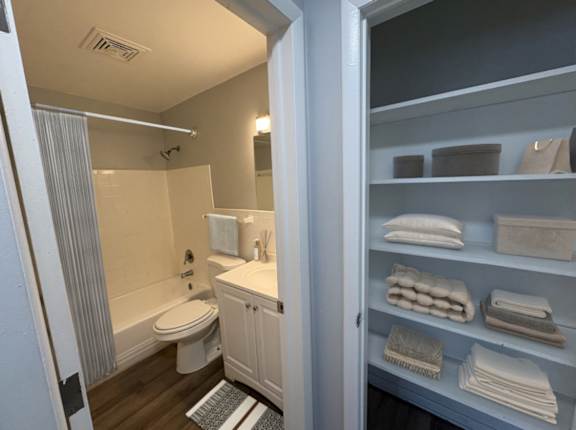 A bathroom with a toilet, sink, and towels.