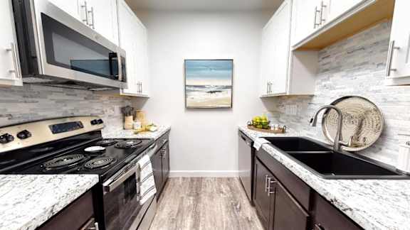 A kitchen with a black stove top oven and a black microwave above it.