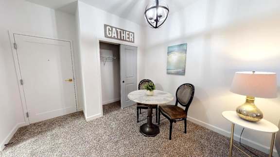 A room with a table, chairs and a lamp.