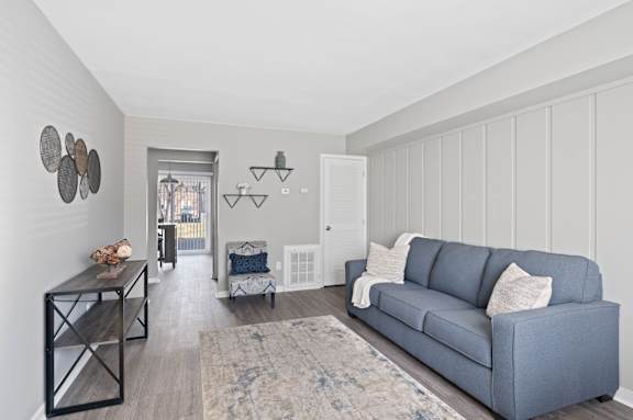 A living room with a grey couch and a rug. at The Parkton, Ohio