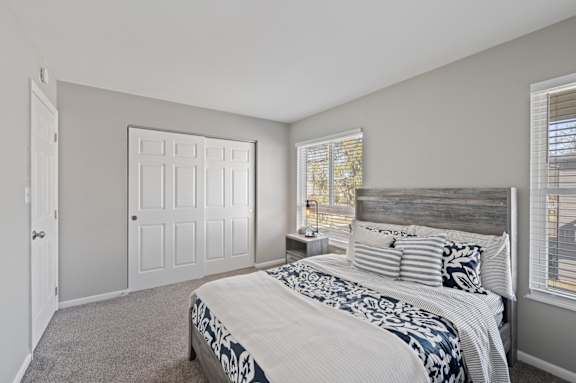 A bedroom with a bed, a window with blinds, and a wooden headboard. at The Parkton, Ohio, 45231