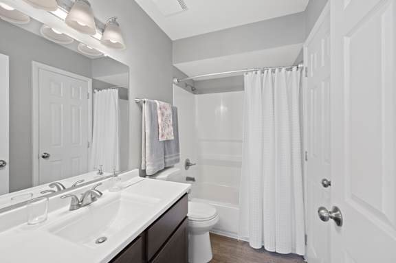 A white bathroom with a toilet, sink, and shower. at The Parkton, Cincinnati, Ohio